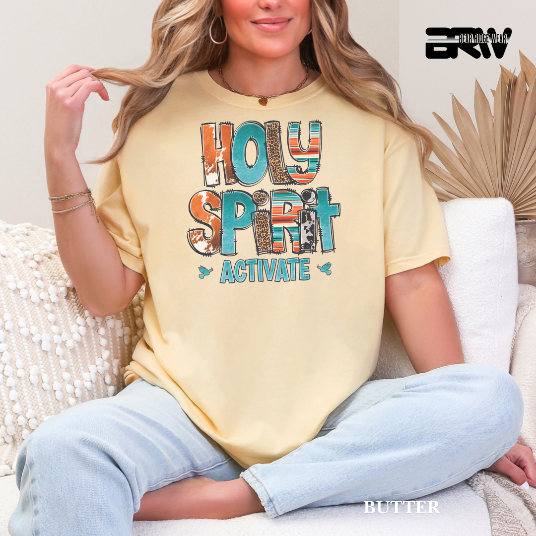Woman wearing a yellow t-shirt with 'HOLY SPIRIT ACTIVATE' text, sitting on a couch.