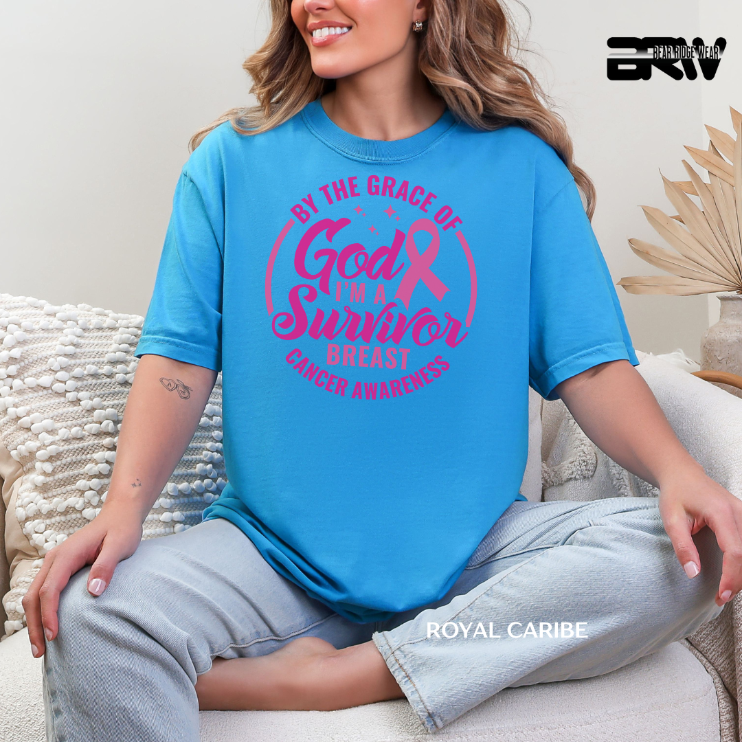 Woman wearing a blue t-shirt with pink breast cancer awareness text, sitting on a couch.