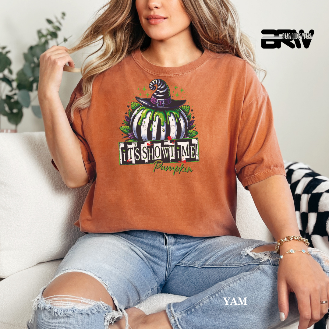 Person wearing a brown t-shirt with a Halloween-themed design, sitting on a couch.