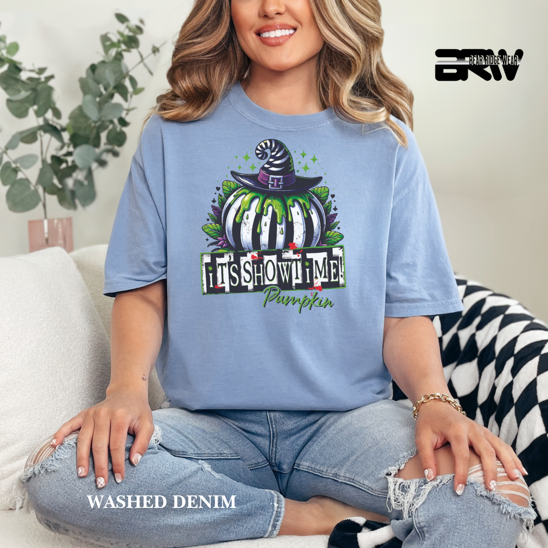 Woman wearing a blue t-shirt with a Halloween-themed design, sitting on a couch.