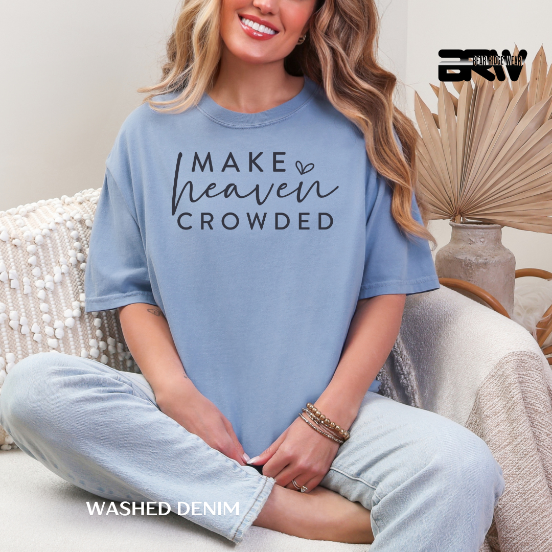 Woman wearing a blue t-shirt with text, sitting on a couch.