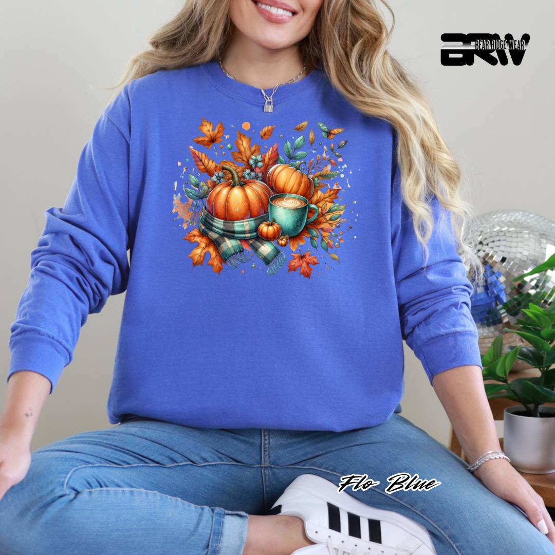 Person wearing a blue sweatshirt with autumn-themed design, sitting indoors.