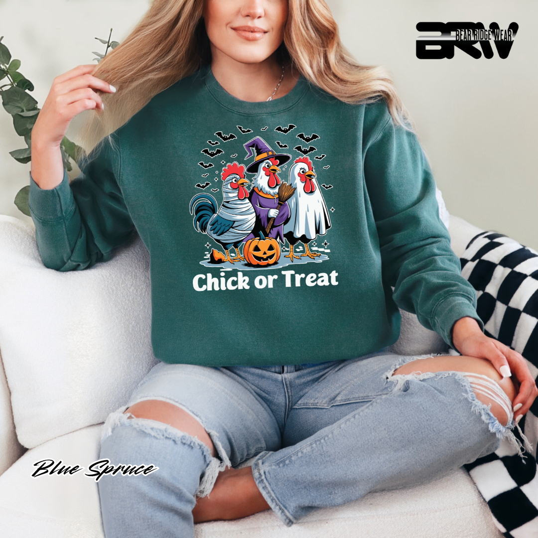 Person wearing a green sweatshirt with Halloween-themed design sitting on a couch.