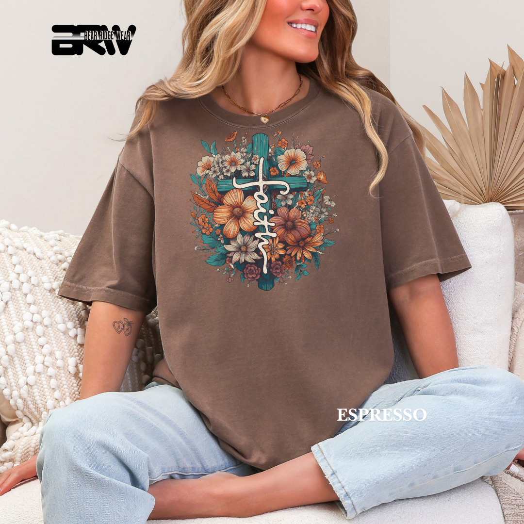 Person wearing a brown t-shirt with floral design and text, sitting on a couch.