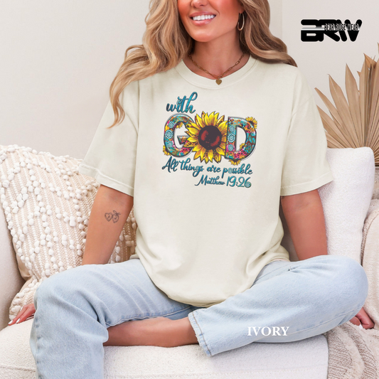 Woman wearing a white t-shirt with a sunflower graphic and text, sitting on a couch.