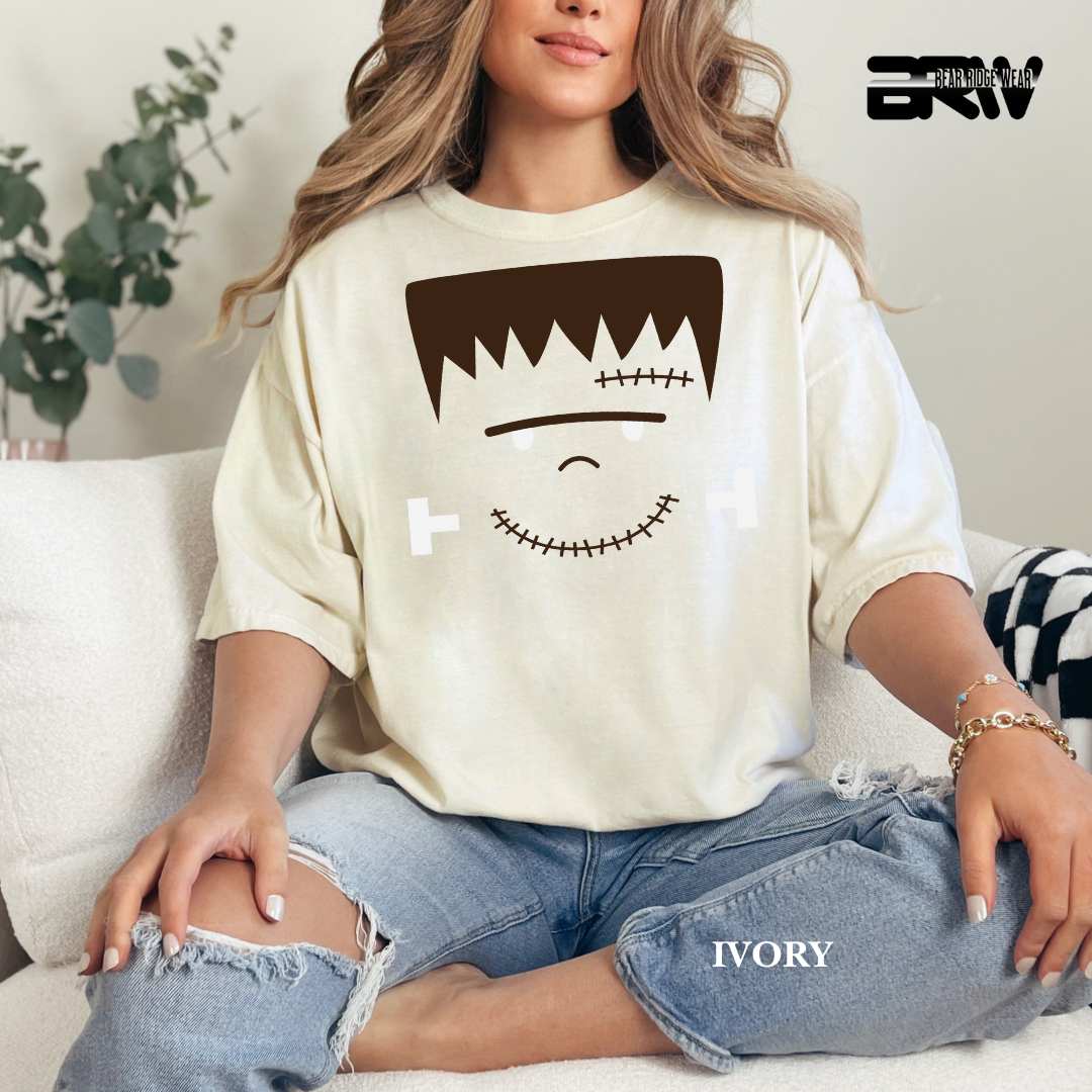 Person wearing a ivory T-shirt with a graphic design sitting on a couch.