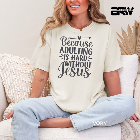 Woman wearing a white t-shirt with text sitting on a couch. BECAUSE ADULTING IS HARD WITHOUT JESUS FAITH TEE