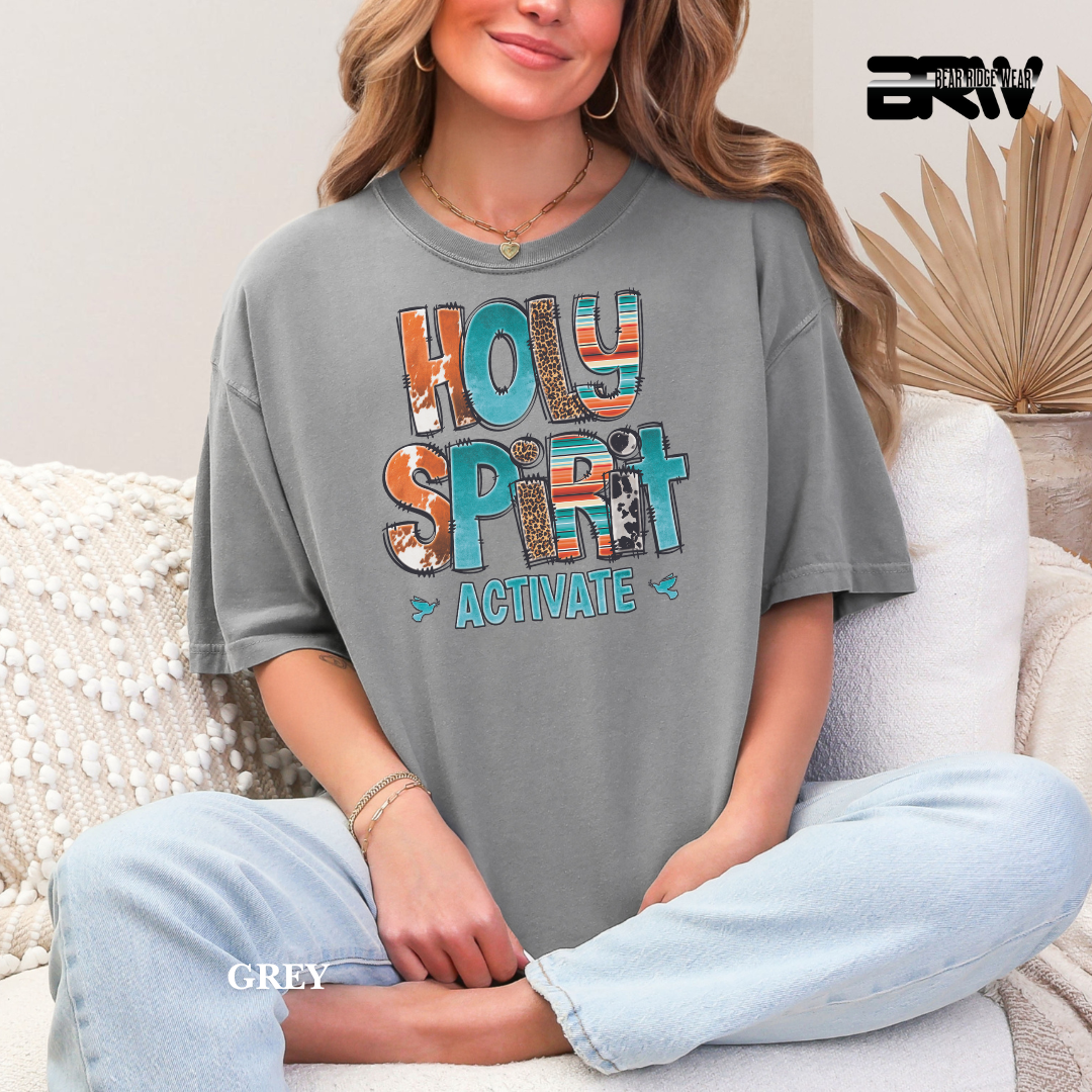 Person wearing a gray t-shirt with 'HOLY SPIRIT ACTIVATE' text, sitting on a couch.