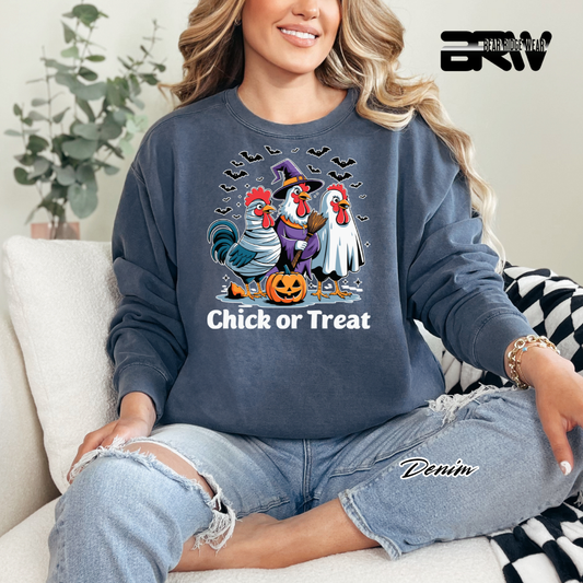 Person wearing a denim sweatshirt with Halloween-themed rooster design, sitting on a couch.