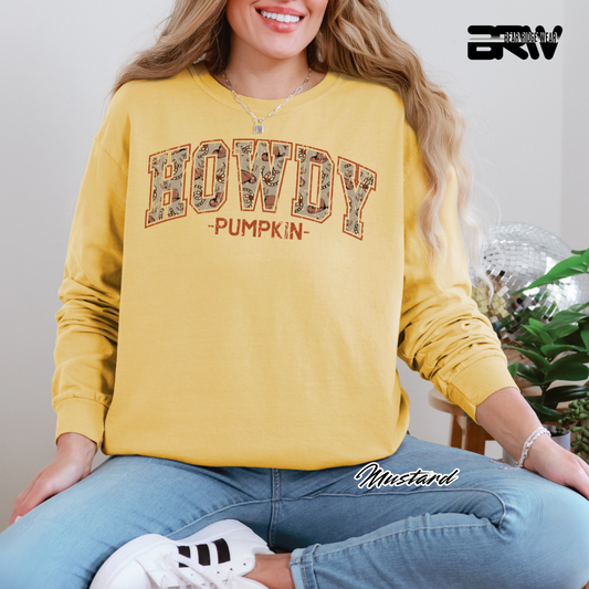 Person wearing a yellow 'HOWDY PUMPKIN' sweatshirt sitting on a couch.