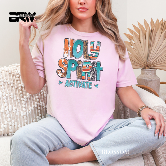 Person wearing a pink t-shirt with 'Holy Spirit Activate' text, sitting on a couch.