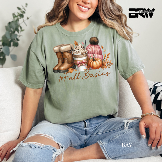 Person wearing a green t-shirt with '#Fall Basics' design, sitting on a couch.