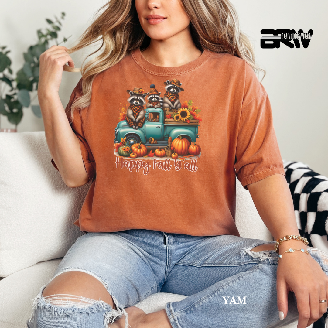 Person wearing a brown t-shirt with a fall-themed graphic and text, sitting on a couch.