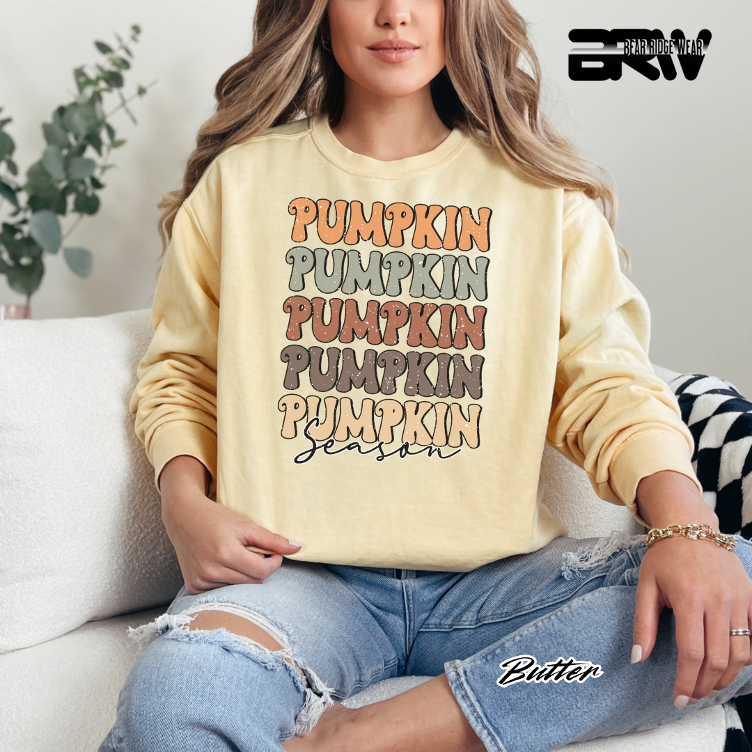 Person wearing a yellow sweatshirt with 'Pumpkin' text, sitting on a couch.