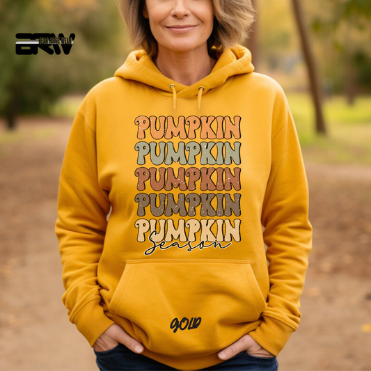Person wearing a yellow hoodie with 'Pumpkin Season' text outdoors.