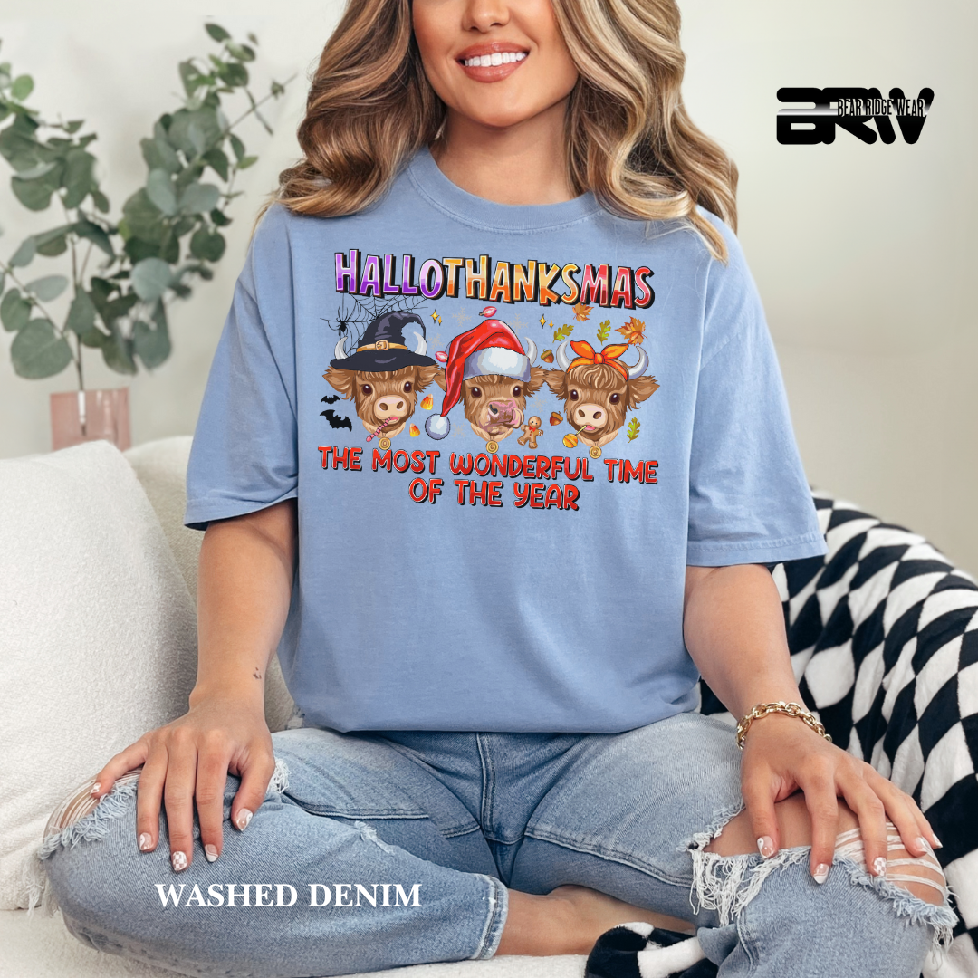 Person wearing a blue t-shirt with 'Hallothanksmas' design, sitting on a couch.