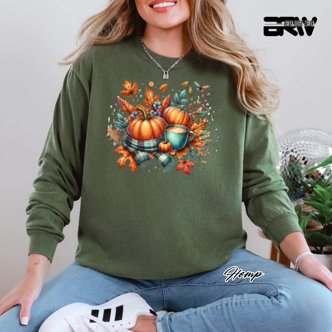 Person wearing a green sweatshirt with autumn-themed design, sitting indoors.