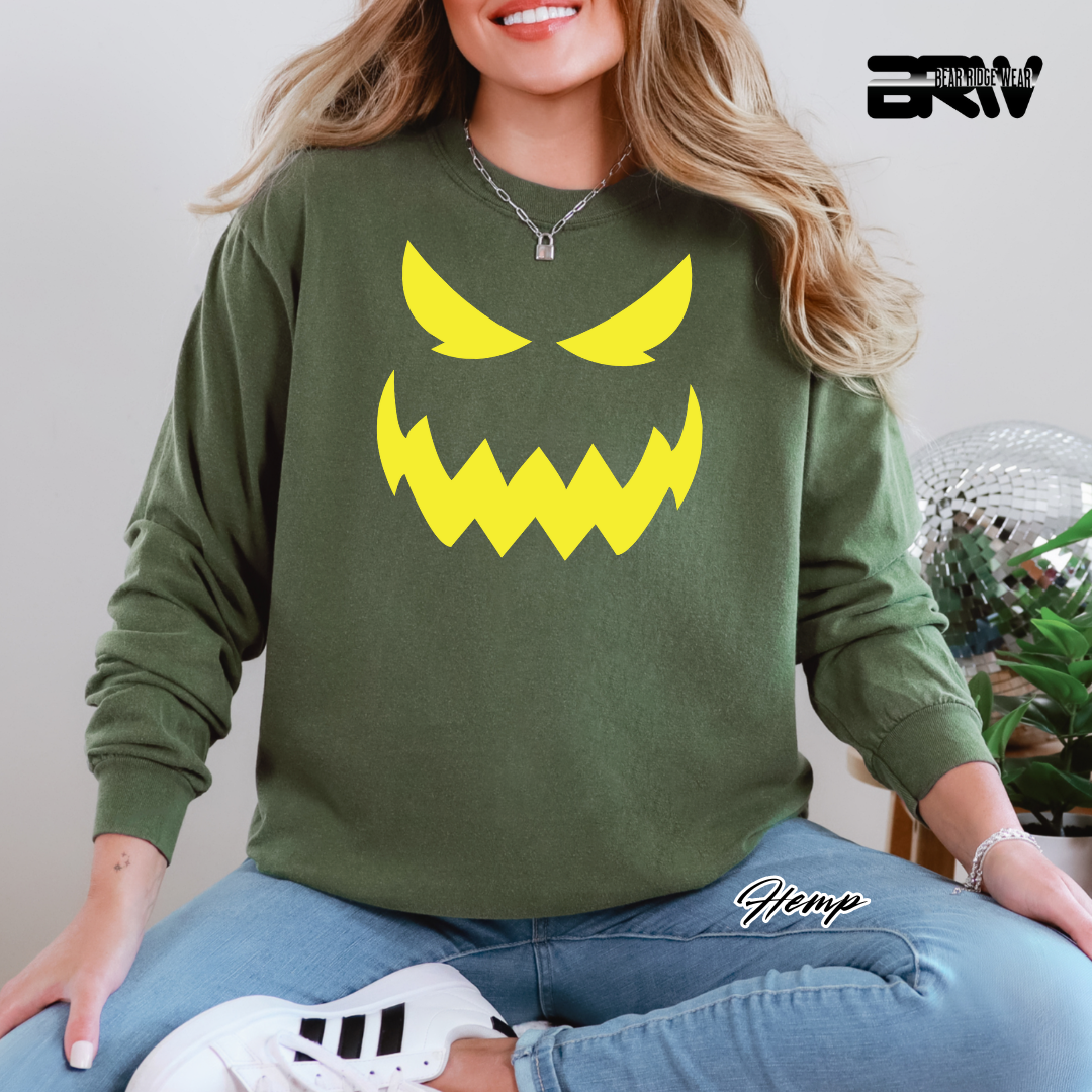 Person wearing a green sweatshirt with a yellow graphic design, sitting indoors.