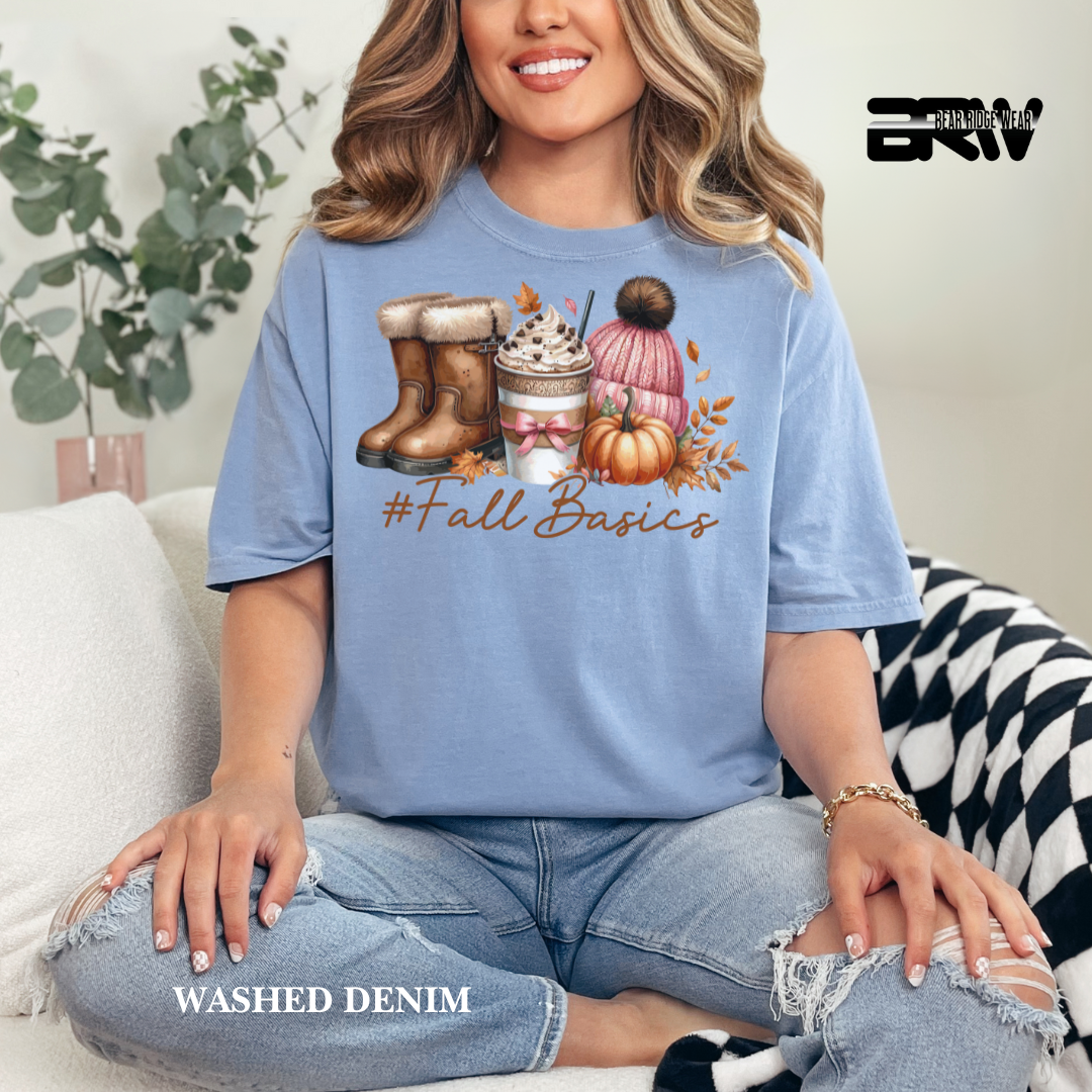 Woman wearing a blue t-shirt with '#Fall Basics' design, sitting on a couch.