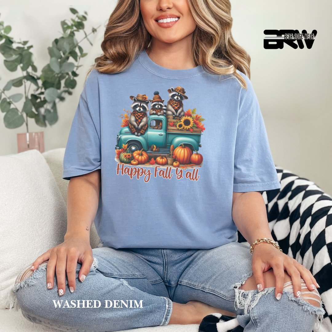 Woman wearing a blue t-shirt with a fall-themed design, sitting on a couch.