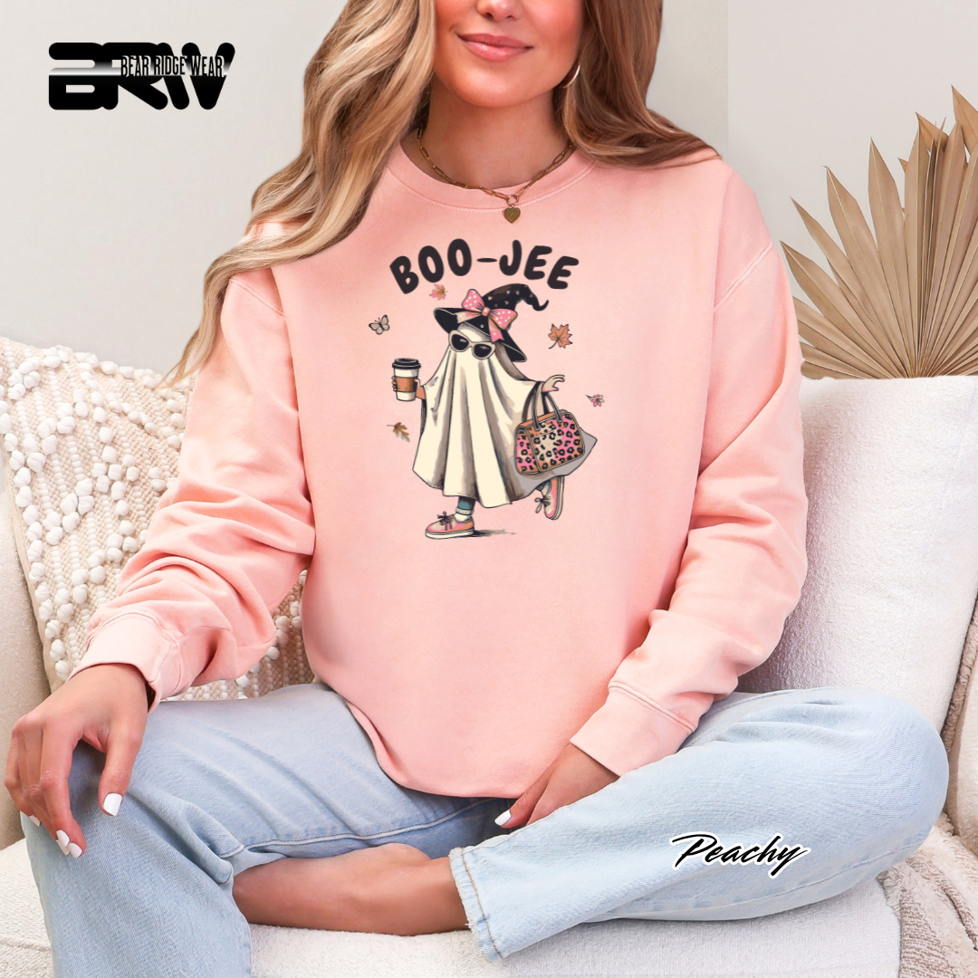 Person wearing a pink sweatshirt with 'BOO-JEE' design sitting on a couch.