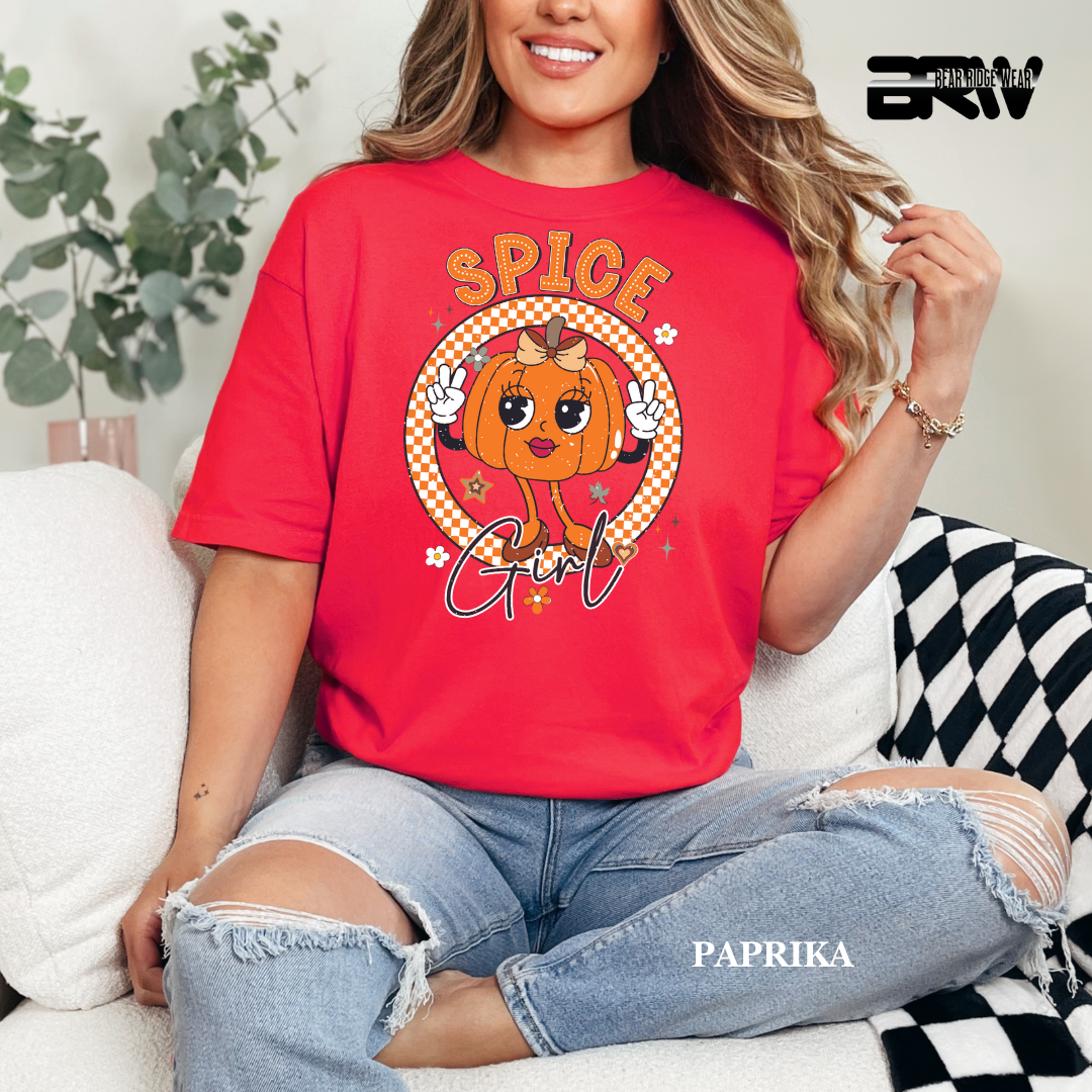 Person wearing a red t-shirt with a pumpkin graphic and text, sitting on a couch.