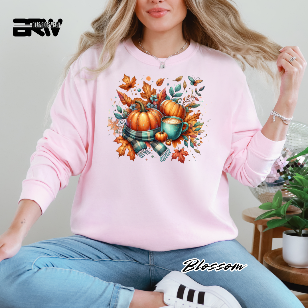 Person wearing a pink sweatshirt with a fall-themed design, sitting indoors.