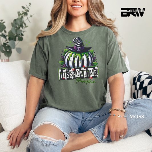 Woman wearing a green t-shirt with a Halloween-themed design, sitting on a couch.
