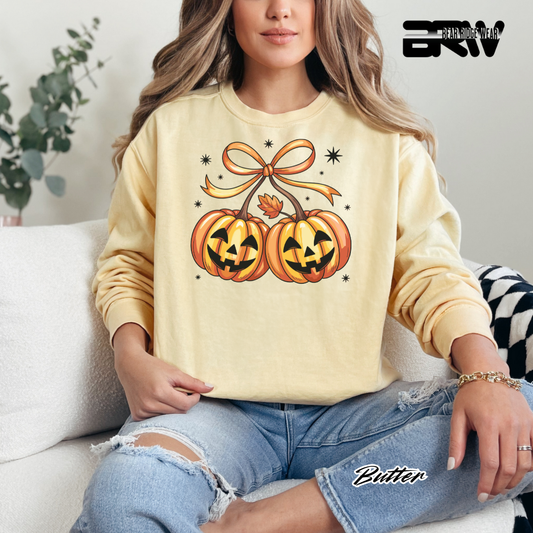 Person wearing a beige sweatshirt with Halloween-themed design sitting on a couch.